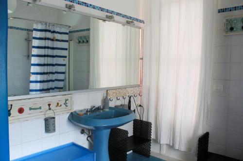 een badkamer met een blauwe wastafel en een spiegel bij Casa Carolina in Giarre