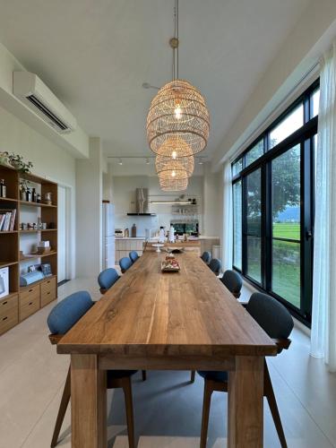 a large dining room with a large wooden table and chairs at 全新根本家民宿 寵物友善 電動麻將 兒童遊戲區 廚房 in Sanxing