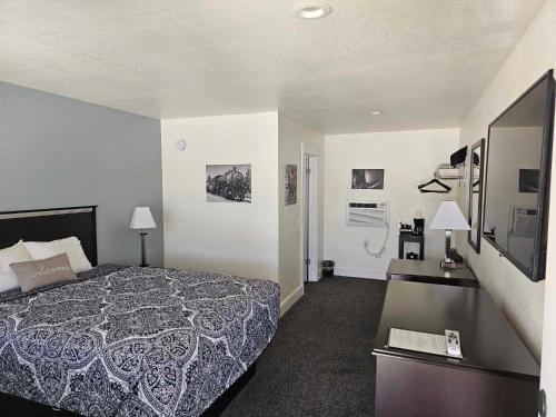 a hotel room with a bed and a television at El Rancho Motel in Williams