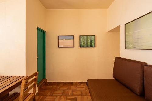 a living room with a couch and a green door at Bungalows Las Arenas in San Patricio Melaque