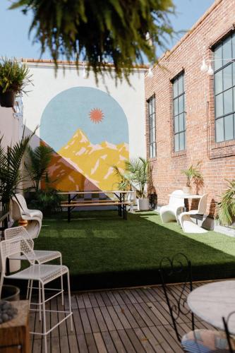 a courtyard with chairs and a mural on the side of a building at Hotel No-Vacancy in Kansas City