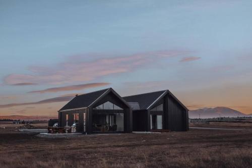 a black house in the middle of a field at Twizel House on Ben Ohau in Twizel