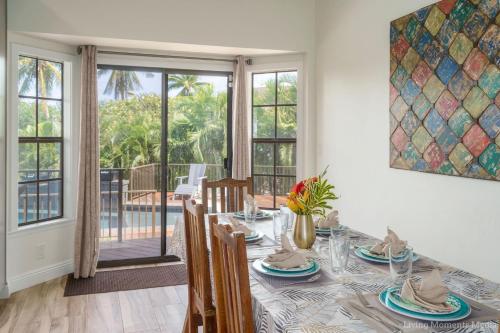 a dining room with a table with chairs and a window at Kaanapali Hini NEW POOL - FULLY REMODELED - Across the Street From Kaanapali Beach in Lahaina