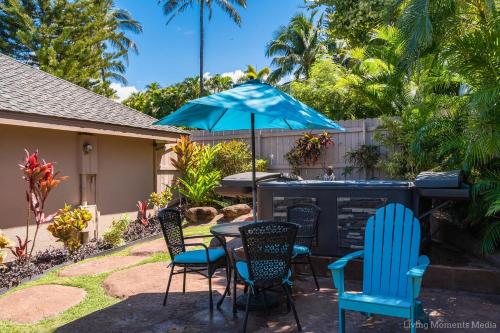 a patio with a table and chairs and an umbrella at Kaanapali Hini NEW POOL - FULLY REMODELED - Across the Street From Kaanapali Beach in Lahaina
