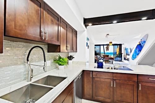 a kitchen with wooden cabinets and a sink at Kahana Villas - F508 - in Kahana
