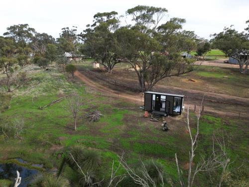 a tiny house sitting on top of a field at McCabe Farm Cabin by Tiny Away in Brookton