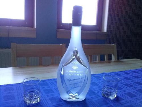 una botella de vino sentada en una mesa con dos copas en Apartments Gaga, en Jahorina