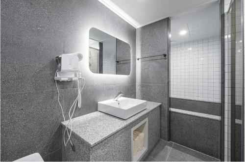 a bathroom with a sink and a mirror at Brown Dot Hotel Andong Ok-dong in Andong