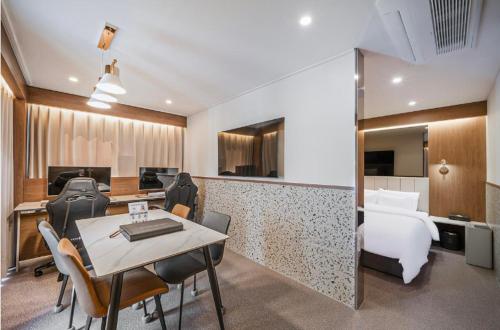 a hotel room with a bed and a table and chairs at Brown Dot Hotel Andong Ok-dong in Andong