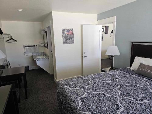 a hotel room with a bed and a bathroom at El Rancho Motel in Williams