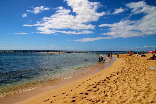 a group of people walking on a beach at Kuhio Shores 215 in Koloa