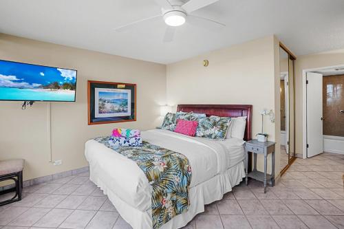 a bedroom with a bed and a tv at Papakea's Finest - OCEAN VIEW Luxury 2 bedroom 2 bath - AC IN EVERY ROOM in Kahana