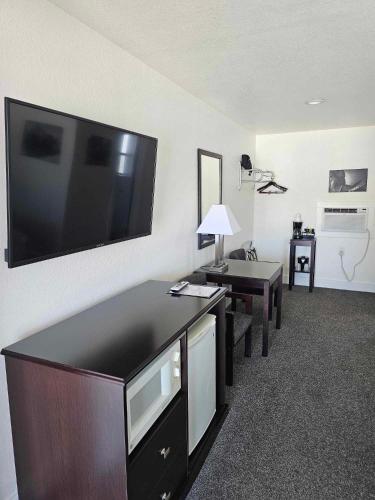 a room with a large flat screen tv on a wall at El Rancho Motel in Williams