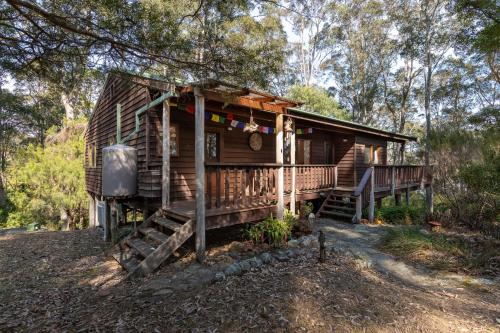 Cabaña de madera en el bosque con porche en 129 Murrah, en Bermagui