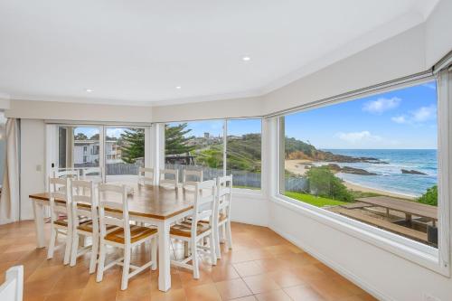 a dining room with a table and views of the ocean at 3 Dickinson Avenue in Bermagui