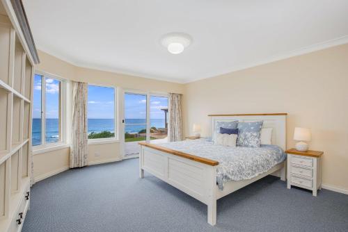 a bedroom with a bed with a view of the ocean at 3 Dickinson Avenue in Bermagui