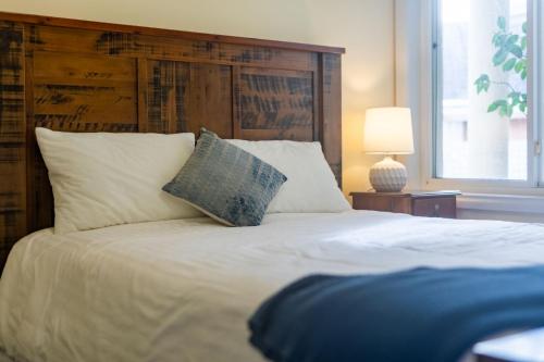 a bedroom with a large white bed with a wooden headboard at 3 Dickinson Avenue in Bermagui