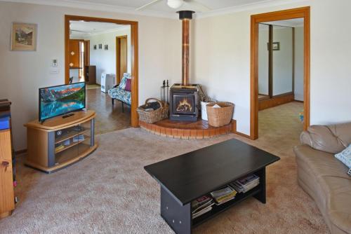 a living room with a couch and a fireplace at 4 Callow in Bermagui