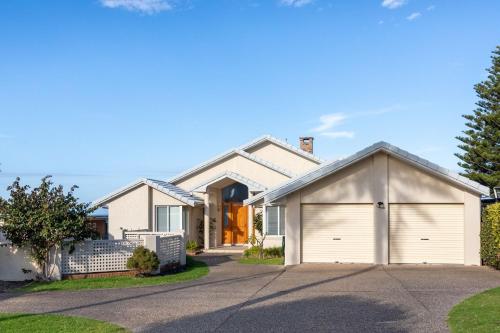 a white house with a garage at 3 Dickinson Avenue in Bermagui