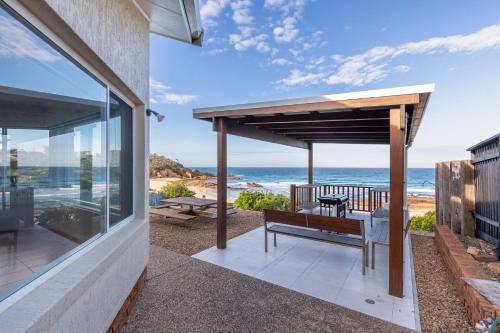 a porch with a bench and a view of the ocean at 3 Dickinson Avenue in Bermagui