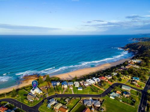 an aerial view of a beach and the ocean at 3 Dickinson Avenue in Bermagui
