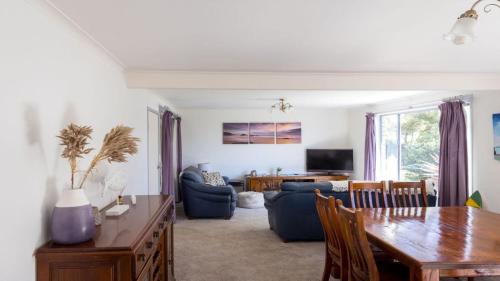 a living room with a table and a dining room at 54 Bunga Street in Bermagui