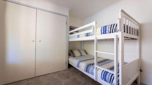 Un dormitorio con dos literas y un armario. en 54 Bunga Street, en Bermagui