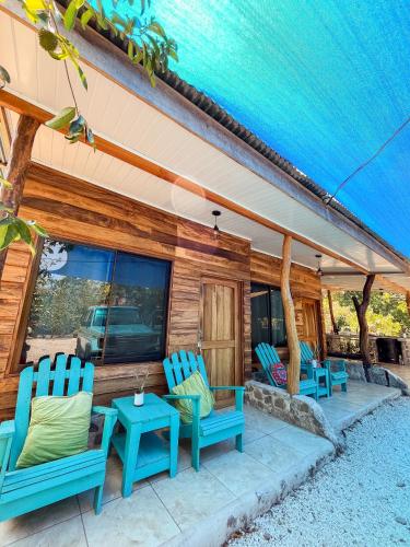 a patio with two blue chairs and a table at Donde Chalo in Paquera