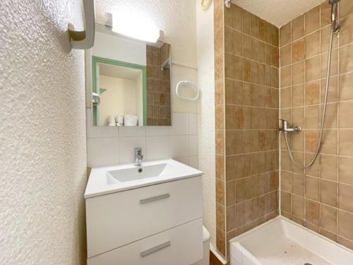 une salle de bain avec un lavabo blanc et une douche dans l'établissement Studio cabine climatisé face plage avec parking et animaux admis - FR-1-338-536, à Sète