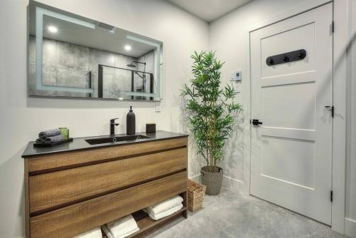 a bathroom with a sink and a mirror and a door at Valhalla Tremblant Cabin Retreat-Your Haven Awaits! in La Conception
