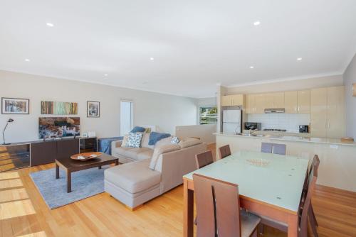 a kitchen and living room with a table and a couch at Seascape 3-7 in Bermagui