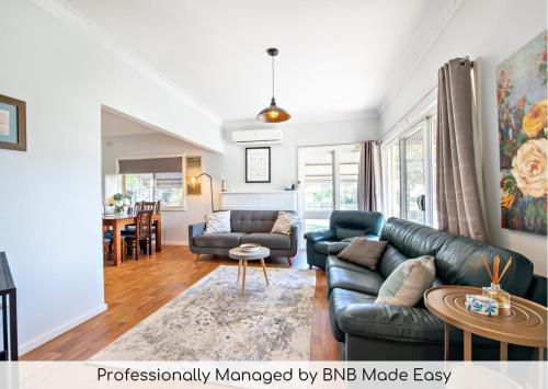 a living room with a couch and a table at Rosewood Cottage - Stroll to Central, Cosy Escape in Dubbo