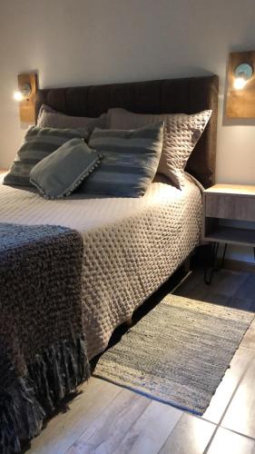 a bedroom with a bed with pillows and a rug at CasaSur- 37Robles in Villa La Angostura