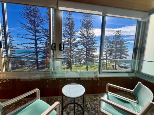 a room with two chairs and a table in front of a window at Park Towers-Goodwin Towers Holiday Units in Gold Coast