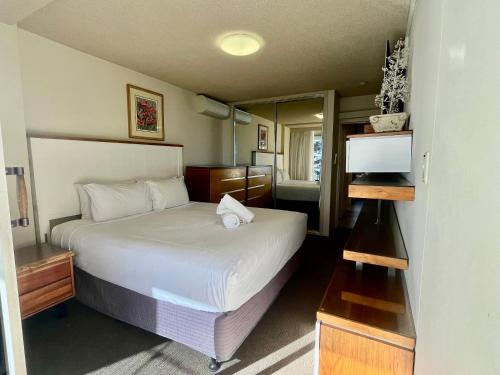 a hotel room with a bed and a mirror at Park Towers-Goodwin Towers Holiday Units in Gold Coast