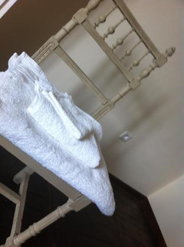 a white towel on a towel rack in a room at La Petite Maison in Magnac-Laval