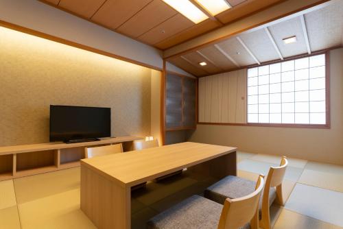 a conference room with a table and a tv at Hotel Associa Toyohashi in Toyohashi