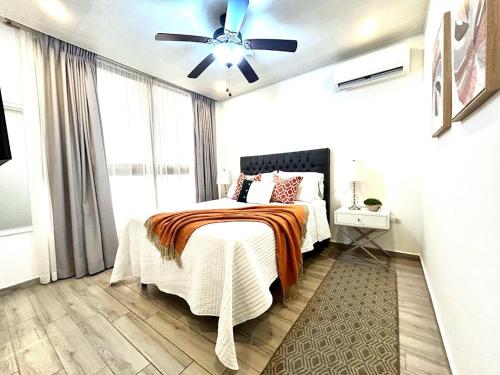 a bedroom with a bed with a ceiling fan at Elegante condominio En Residenza Con vista al Merendon in San Pedro Sula