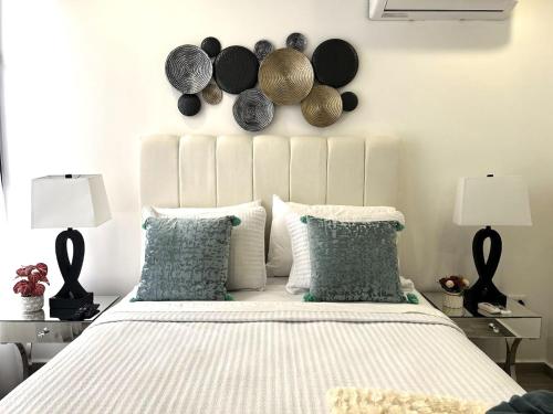 a bedroom with a bed with pillows and hats on the wall at Elegante condominio En Residenza Con vista al Merendon in San Pedro Sula