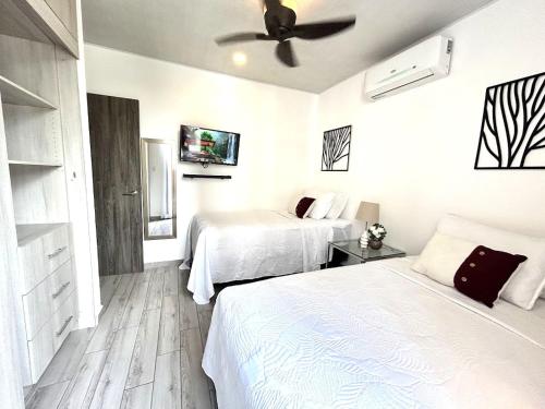 a bedroom with two beds and a ceiling fan at Elegante condominio En Residenza Con vista al Merendon in San Pedro Sula
