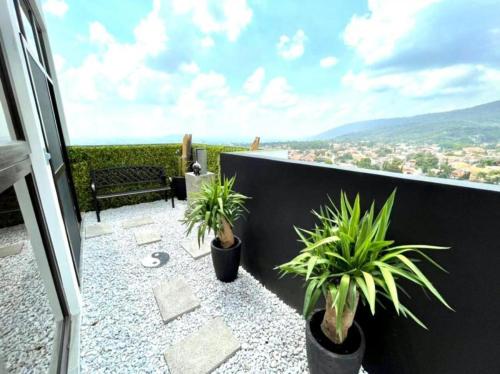 a balcony with two potted plants and a bench at Elegante condominio En Residenza Con vista al Merendon in San Pedro Sula