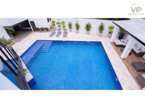 a large blue swimming pool with chairs next to a building at Elegante condominio En Residenza Con vista al Merendon in San Pedro Sula