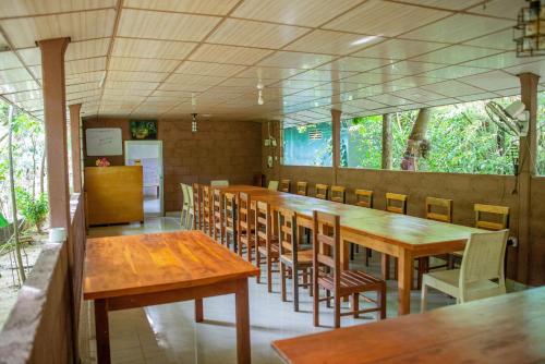 a dining room with wooden tables and chairs at Silent Bungalow in Udawalawe