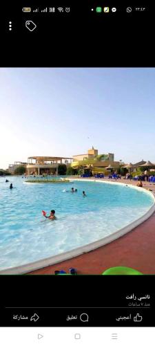 a group of people swimming in a swimming pool at شاليه ديمورا عائلات فقط Dimora Chalet Only Family in Dawwār Muḩammad Abū Shunaynah