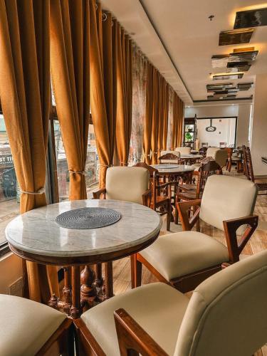 a restaurant with tables and chairs and curtains at Charos Dormitel in Dumaguete