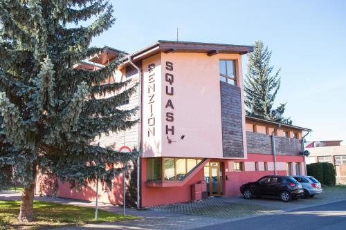 a building with a sign for a hotel at Penzión Squash in Liptovský Mikuláš