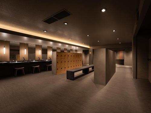 a bathroom with sinks and a bench in a room at Grand Mercure Nara Kashihara in Kashihara