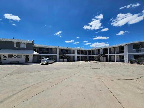 a large building with a car parked in a parking lot at El Rancho Motel in Williams