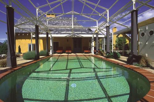 a swimming pool with green water in a building at Arty Luxury Barn Apartment in Closeburn