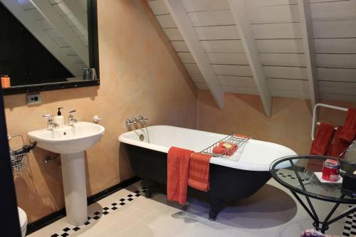 a bathroom with a sink and a bath tub next to a sink at Arty Luxury Barn Apartment in Closeburn